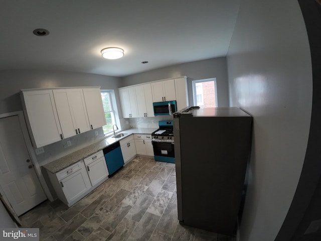 1632 Moreland Ave, Baltimore, MD 21216 - kitchen with gas range, stainless steel microwave, dishwashing machine, white cabinetry, and a sink