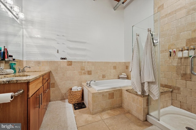 full bathroom featuring a garden tub, tile patterned floors, tile walls, a shower stall, and vanity