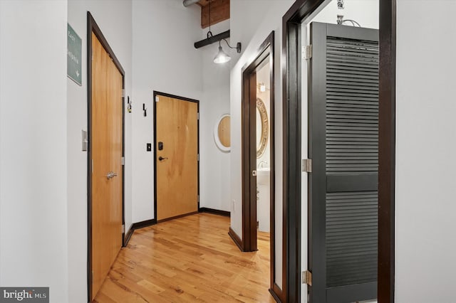 hall with baseboards and light wood-style flooring