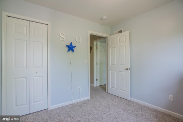 unfurnished bedroom with carpet floors, baseboards, a closet, and visible vents