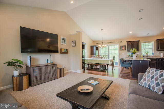 living area featuring an inviting chandelier, recessed lighting, baseboards, and lofted ceiling