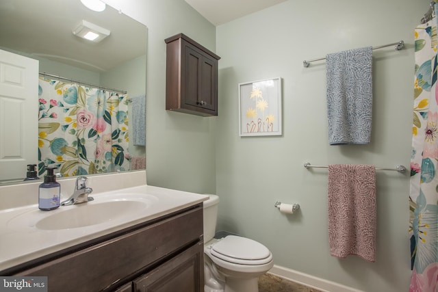 full bath featuring toilet, baseboards, and vanity