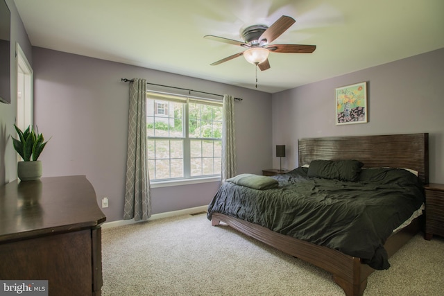 carpeted bedroom featuring baseboards and ceiling fan