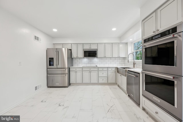 kitchen with a sink, light countertops, stainless steel appliances, and visible vents