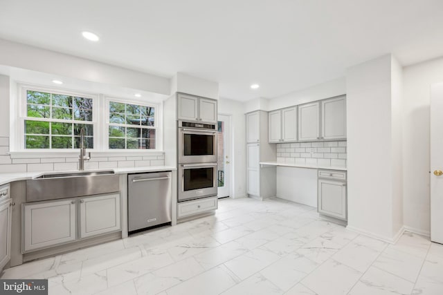 kitchen featuring a sink, light countertops, gray cabinets, marble finish floor, and stainless steel appliances