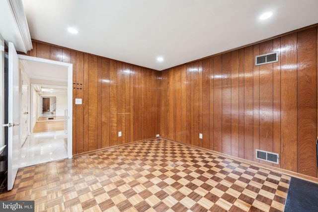 empty room featuring recessed lighting, wood walls, and visible vents
