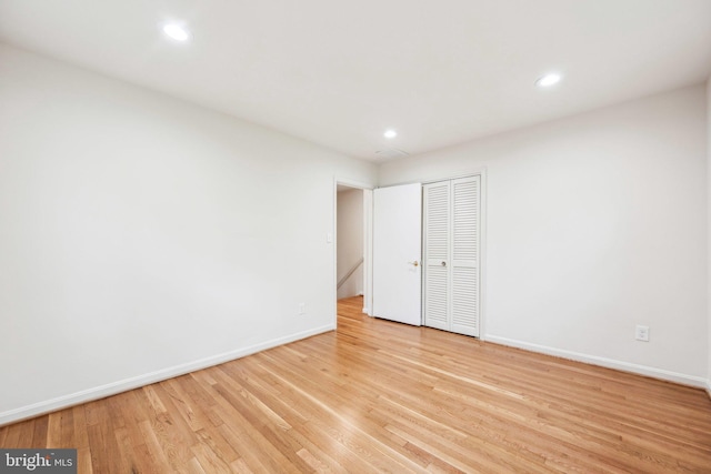 unfurnished room with recessed lighting, baseboards, and light wood-type flooring