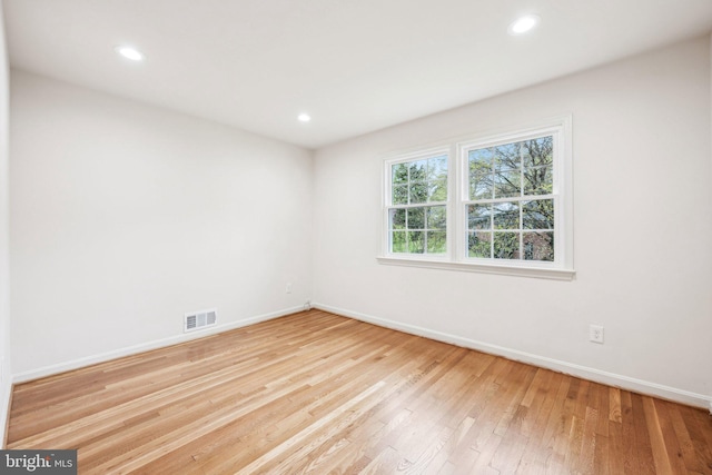 empty room with wood-type flooring, recessed lighting, baseboards, and visible vents
