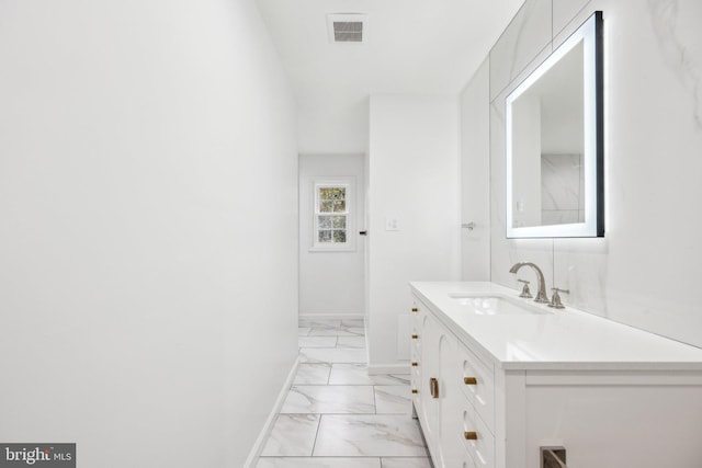 bathroom featuring visible vents, marble finish floor, baseboards, and vanity