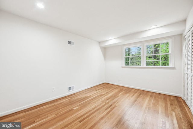 spare room featuring baseboards, recessed lighting, wood finished floors, and visible vents