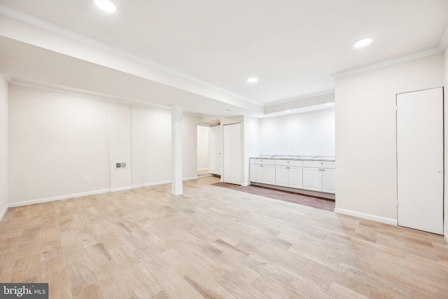finished below grade area with crown molding, recessed lighting, light wood-style flooring, and baseboards