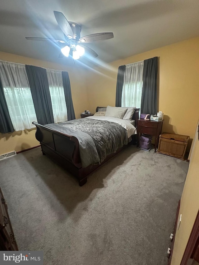 bedroom featuring carpet floors, multiple windows, ceiling fan, and visible vents