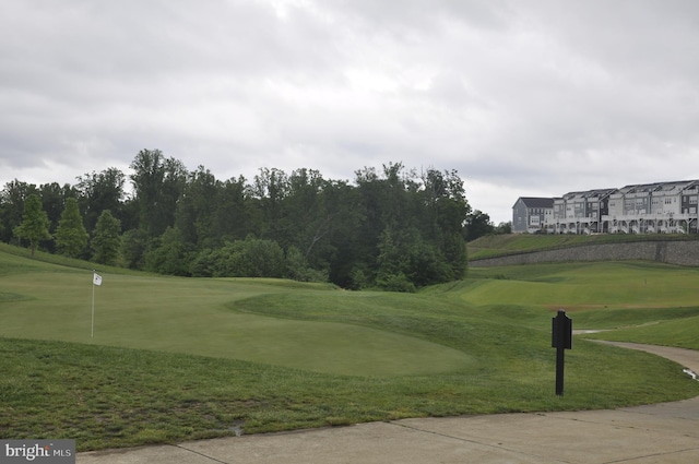 view of community with view of golf course and a yard