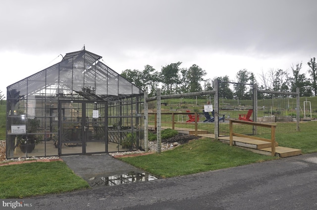 exterior space with a yard, fence, and an exterior structure