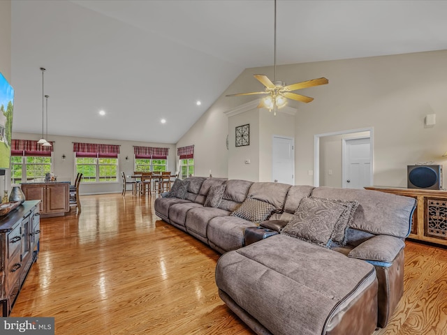living area with high vaulted ceiling, light wood-type flooring, ceiling fan, and recessed lighting