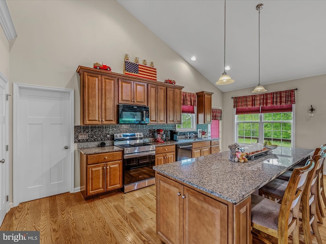 kitchen featuring black microwave, stainless steel range with electric stovetop, dishwashing machine, high vaulted ceiling, and brown cabinets