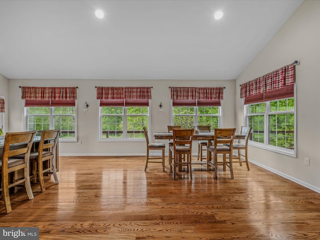 dining area featuring healthy amount of natural light, wood finished floors, baseboards, lofted ceiling, and recessed lighting