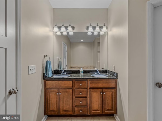 full bath with double vanity, tile patterned flooring, and baseboards
