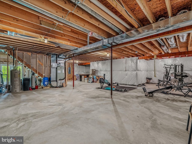 basement with heating unit, water heater, a water softener, and a water pressure tank