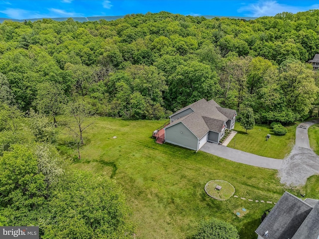 aerial view of property and surrounding area featuring a heavily wooded area