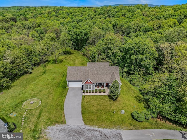 aerial view of property and surrounding area featuring a forest