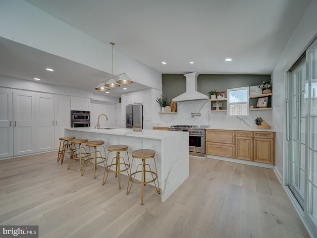1782 Shaftsbury Ave, Crofton, MD 21114 - kitchen featuring appliances with stainless steel finishes, wall chimney exhaust hood, a sink, open shelves, and light wood-type flooring