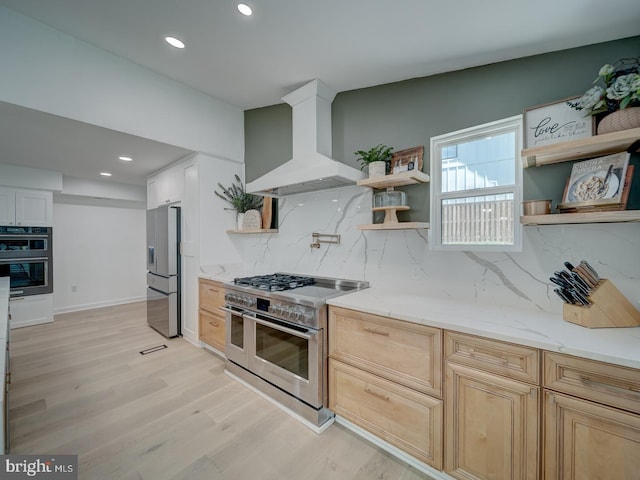 1782 Shaftsbury Ave, Crofton, MD 21114 - kitchen featuring stainless steel appliances, wall chimney range hood, open shelves, light wood-style floors, and backsplash