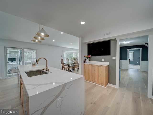 1782 Shaftsbury Ave, Crofton, MD 21114 - kitchen featuring a sink, light wood-style flooring, light stone counters, an island with sink, and recessed lighting