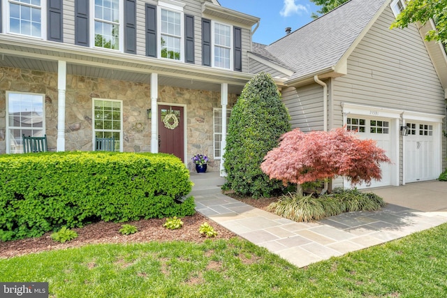 21591 Awbrey Pl, Broadlands, VA 20148 - view of front facade featuring stone siding, covered porch, driveway, and a shingled roof