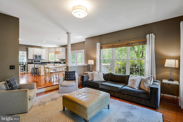21591 Awbrey Pl, Broadlands, VA 20148 - living room featuring light wood finished floors, ornate columns, recessed lighting, and baseboards