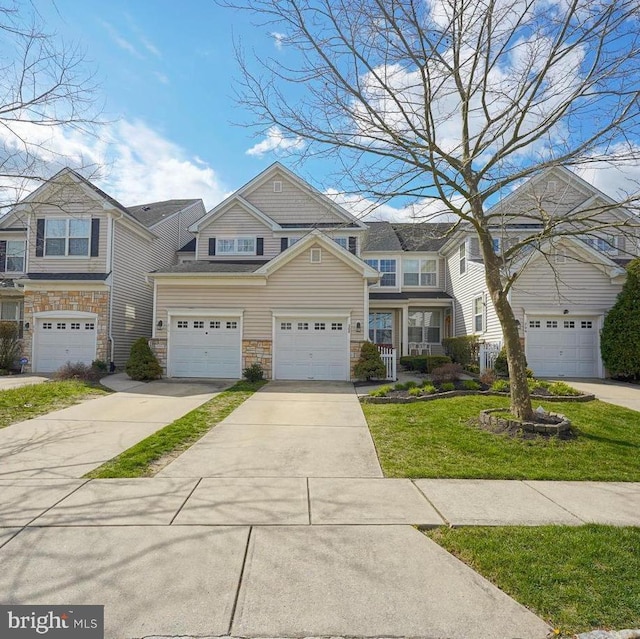 multi unit property with stone siding, driveway, and a front lawn