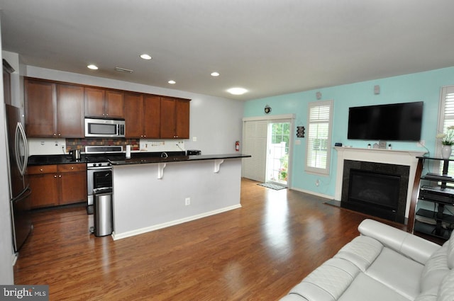 208 Starboard Way, Mount Laurel, NJ 08054 - kitchen featuring open floor plan, appliances with stainless steel finishes, dark countertops, dark wood-type flooring, and a kitchen bar