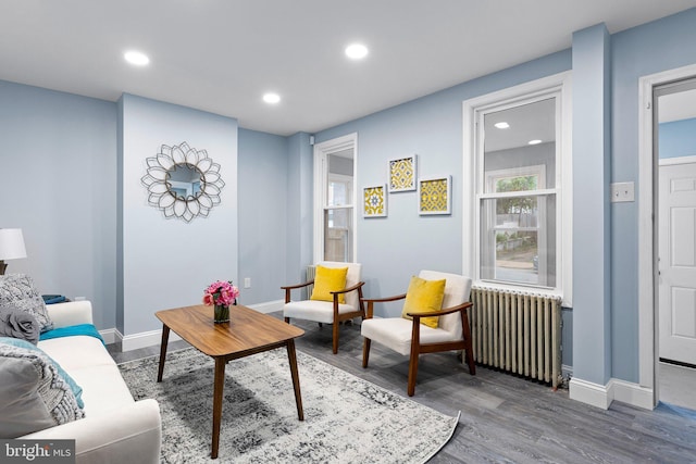 living area featuring recessed lighting, wood finished floors, baseboards, and radiator heating unit