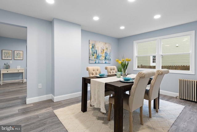 dining room featuring baseboards, radiator, recessed lighting, and wood finished floors
