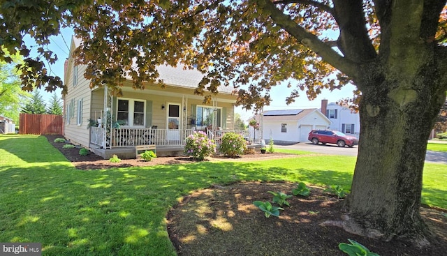 view of front of home with covered porch, fence, and a front yard