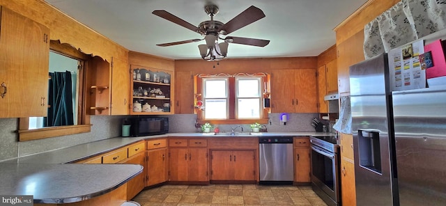 8074 Molly Pitcher Hwy, Shippensburg, PA 17257 - kitchen with appliances with stainless steel finishes, under cabinet range hood, backsplash, brown cabinetry, and ceiling fan