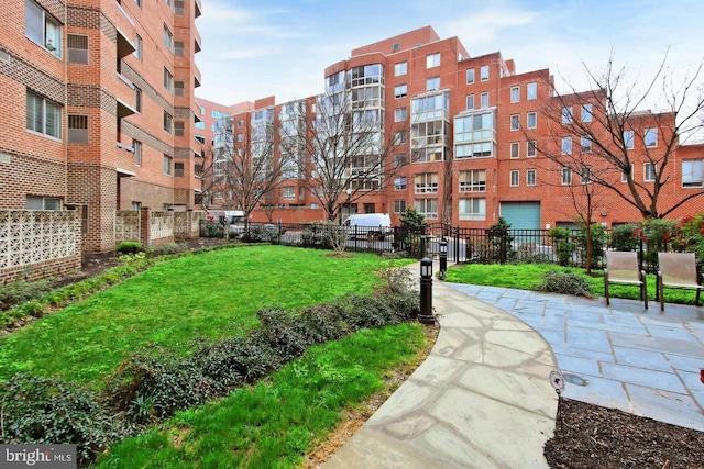 view of property's community featuring fence and a lawn