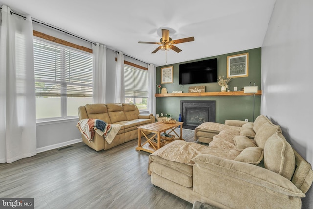 31 Walters Way, Dover, DE 19904 - living area featuring plenty of natural light, a glass covered fireplace, a ceiling fan, and wood finished floors