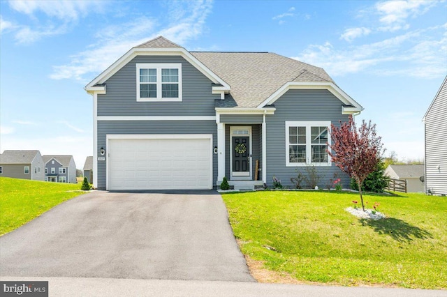 view of front of home with an attached garage, driveway, roof with shingles, and a front lawn