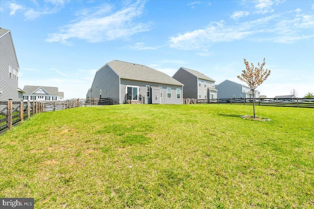 back of property featuring entry steps, a yard, and a fenced backyard