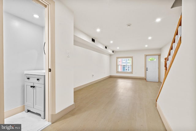 spare room with light wood-type flooring, recessed lighting, stairs, and baseboards