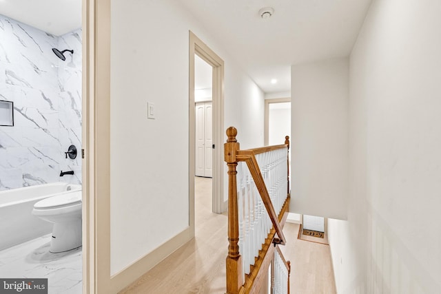 hallway with recessed lighting, baseboards, light wood finished floors, and an upstairs landing