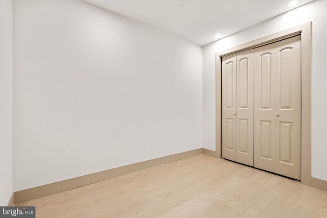 unfurnished bedroom featuring recessed lighting, light wood finished floors, baseboards, and a closet