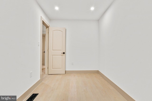 spare room with baseboards, recessed lighting, wood finished floors, and visible vents