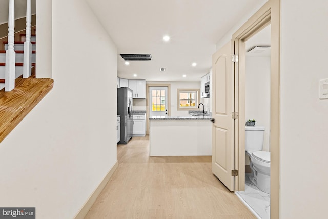 corridor featuring visible vents, recessed lighting, and light wood-style floors