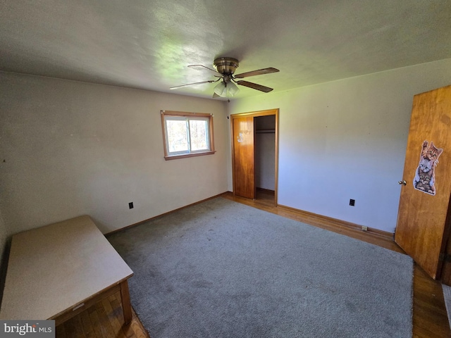 unfurnished bedroom with baseboards, ceiling fan, and a closet