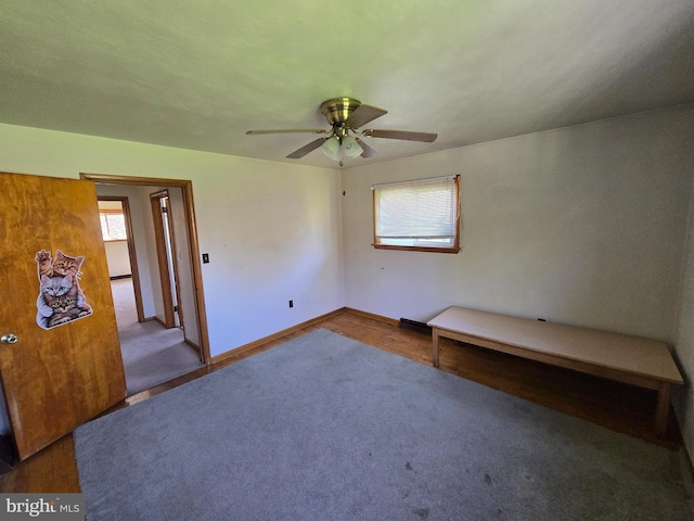 carpeted empty room with a ceiling fan and baseboards