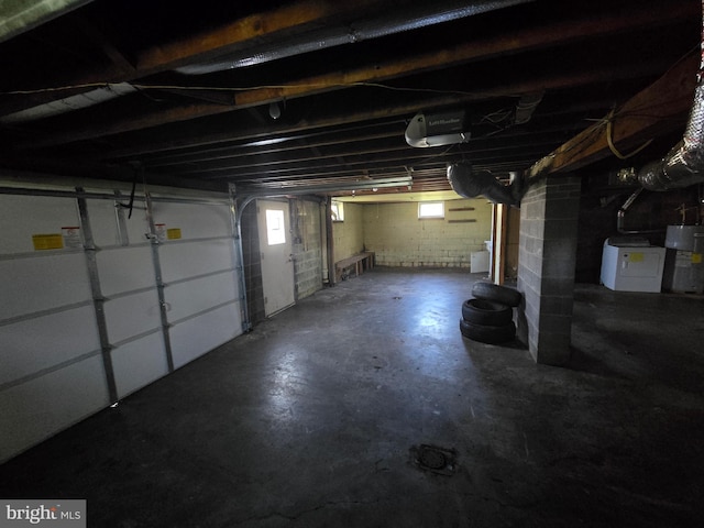 garage featuring water heater and washer / dryer