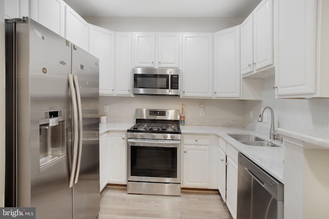 2350 Merseyside Dr, Woodbridge, VA 22191 - kitchen featuring stainless steel appliances, a sink, white cabinetry, light wood finished floors, and backsplash