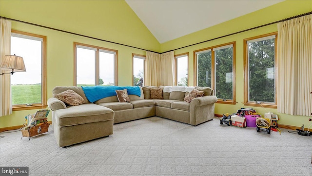 living area with healthy amount of natural light, vaulted ceiling, and baseboards